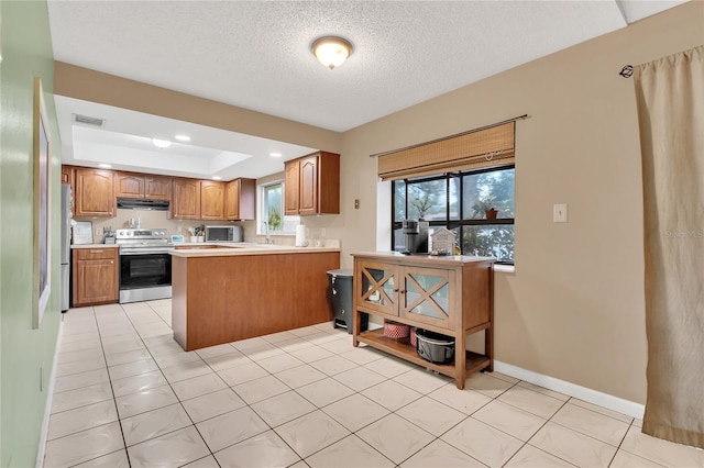 kitchen featuring stainless steel appliances, a raised ceiling, kitchen peninsula, a textured ceiling, and light tile patterned flooring