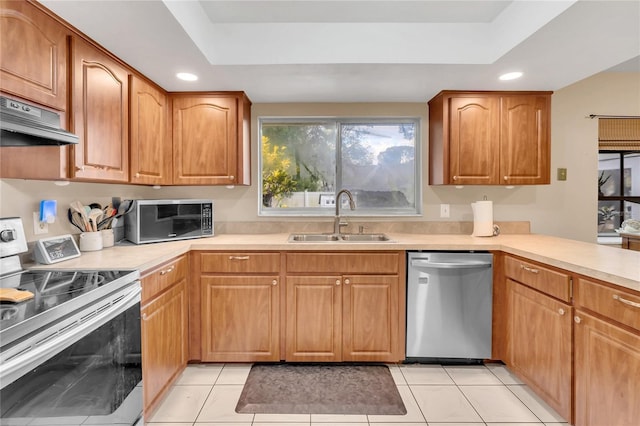 kitchen featuring appliances with stainless steel finishes, a raised ceiling, exhaust hood, sink, and light tile patterned flooring