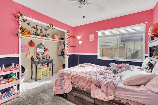 carpeted bedroom with ceiling fan and a textured ceiling