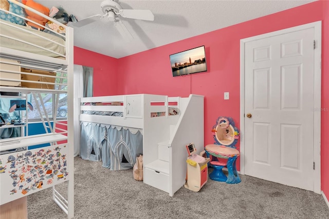 carpeted bedroom with ceiling fan and a textured ceiling