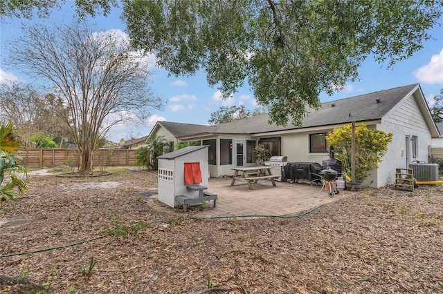 rear view of property featuring a sunroom, a patio area, and central AC