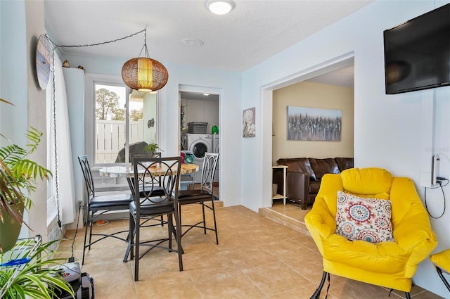 dining space with light tile patterned floors and independent washer and dryer