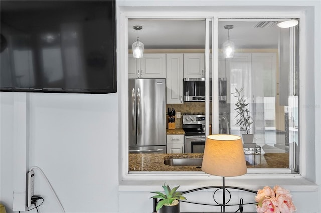 kitchen with white cabinets, decorative backsplash, and stainless steel appliances