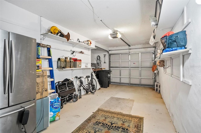 garage featuring stainless steel refrigerator and a garage door opener