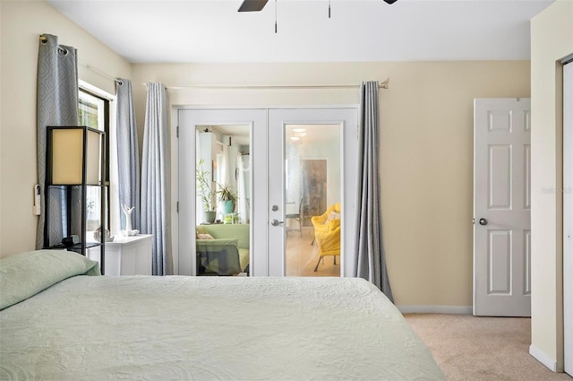 carpeted bedroom with connected bathroom, ceiling fan, and french doors