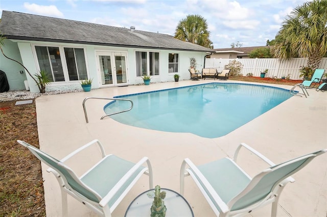 view of swimming pool with a patio area and french doors