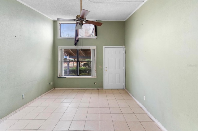 tiled empty room featuring ceiling fan and a textured ceiling