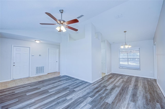 unfurnished living room featuring ceiling fan with notable chandelier, hardwood / wood-style floors, and high vaulted ceiling