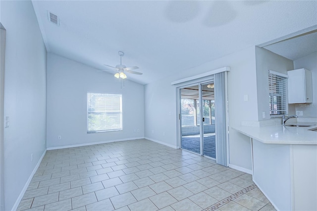 interior space with sink, vaulted ceiling, ceiling fan, and light tile patterned flooring