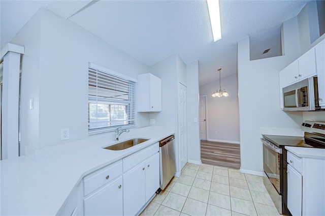 kitchen featuring sink, an inviting chandelier, stainless steel appliances, white cabinets, and decorative light fixtures