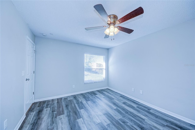 empty room with ceiling fan, dark hardwood / wood-style floors, and a textured ceiling