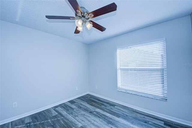 empty room with ceiling fan, dark wood-type flooring, and a textured ceiling