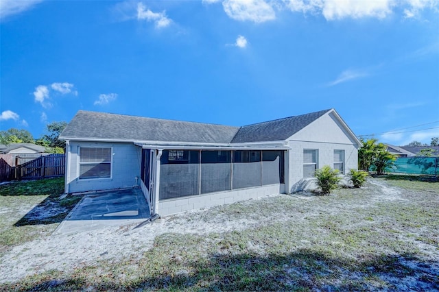 rear view of property featuring a sunroom and a patio area