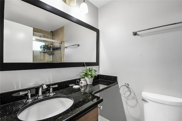 bathroom featuring vanity, toilet, and a stall shower