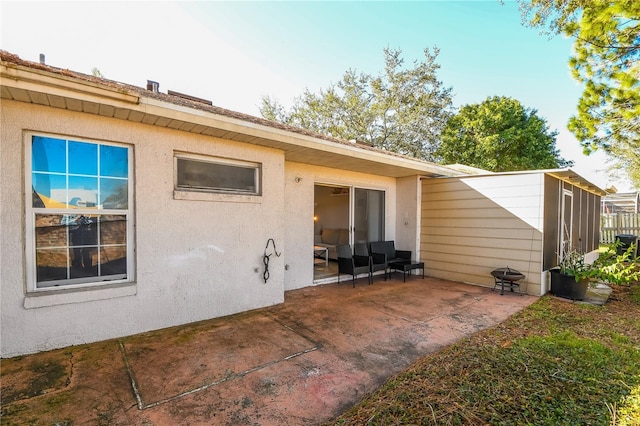 rear view of house with a patio area and stucco siding