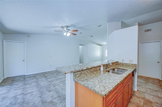 kitchen with a textured ceiling, lofted ceiling, sink, ceiling fan, and light stone counters