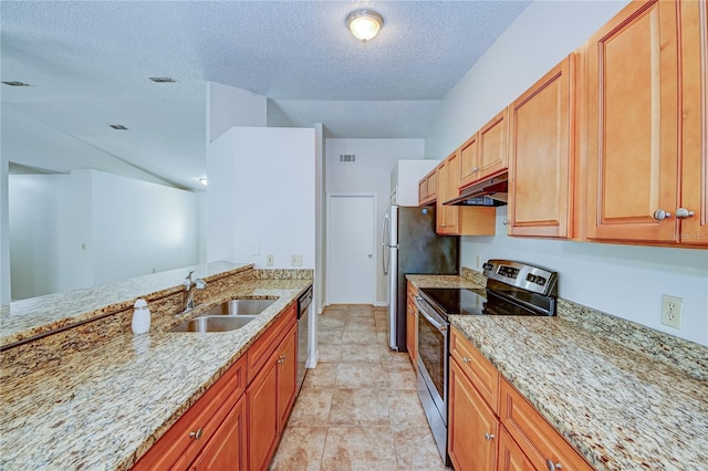 kitchen featuring sink, light stone counters, a textured ceiling, and appliances with stainless steel finishes