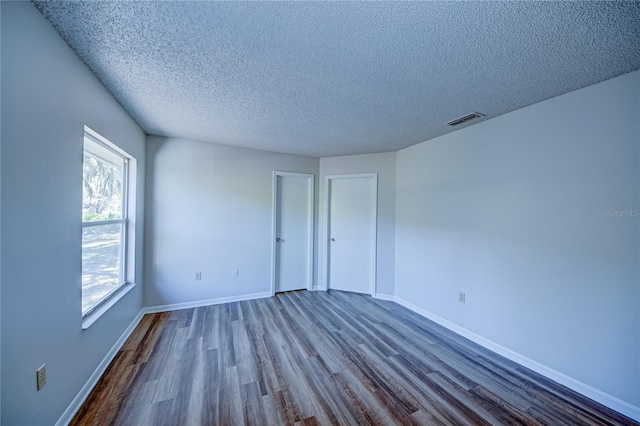 unfurnished room featuring hardwood / wood-style floors and a textured ceiling