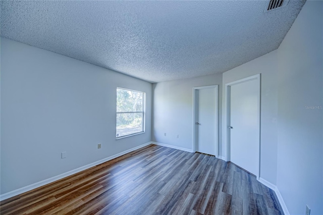 unfurnished bedroom featuring wood-type flooring and a textured ceiling