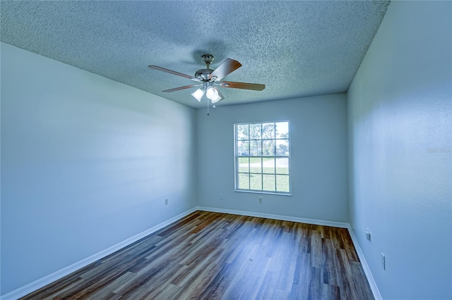 empty room with ceiling fan, dark hardwood / wood-style floors, and a textured ceiling