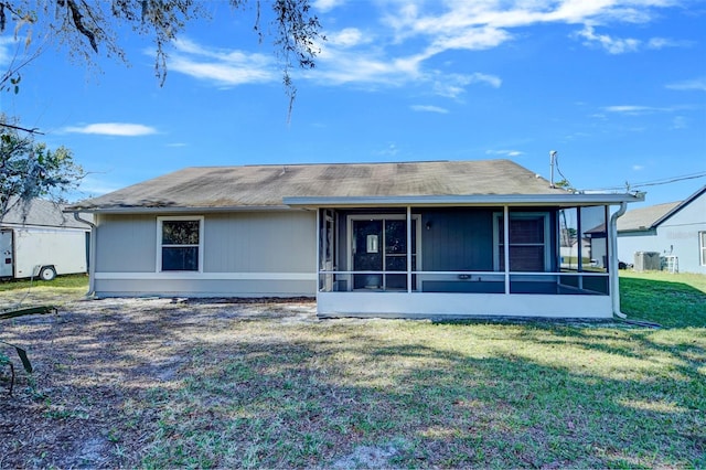 rear view of property with central AC, a yard, and a sunroom