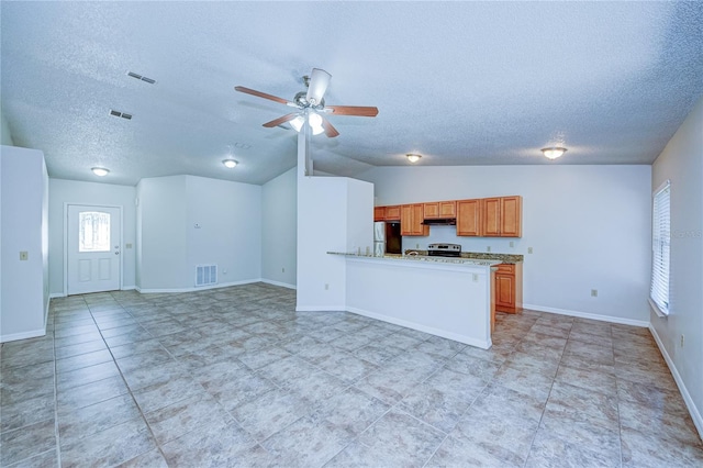 637 Twin Lake Ave, Deltona, FL 32738 - kitchen featuring freestanding refrigerator, a textured ceiling, a ceiling fan, lofted ceiling, and brown cabinetry