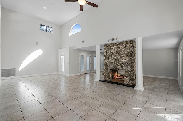 unfurnished living room with visible vents, baseboards, ceiling fan, a fireplace, and light tile patterned flooring