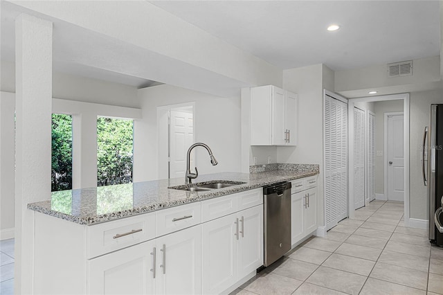 kitchen with visible vents, light stone counters, a peninsula, stainless steel appliances, and a sink