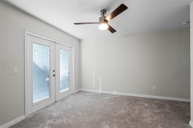 spare room with carpet floors, french doors, and baseboards