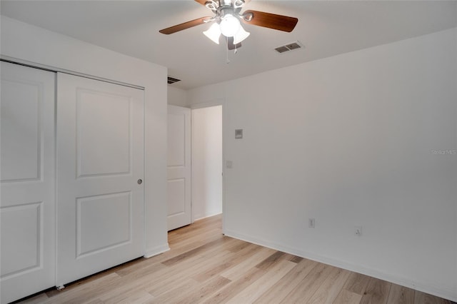 unfurnished bedroom with light hardwood / wood-style flooring, a closet, and ceiling fan