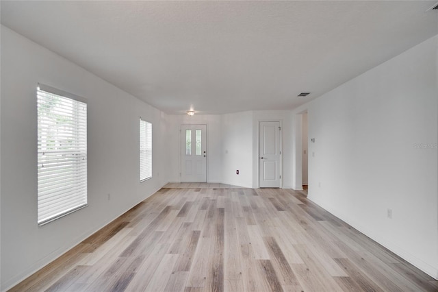 empty room with light hardwood / wood-style flooring