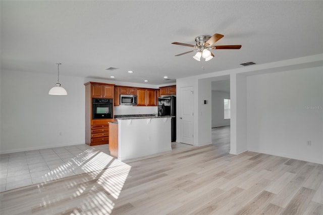 kitchen with hanging light fixtures, light wood-type flooring, ceiling fan, and black appliances