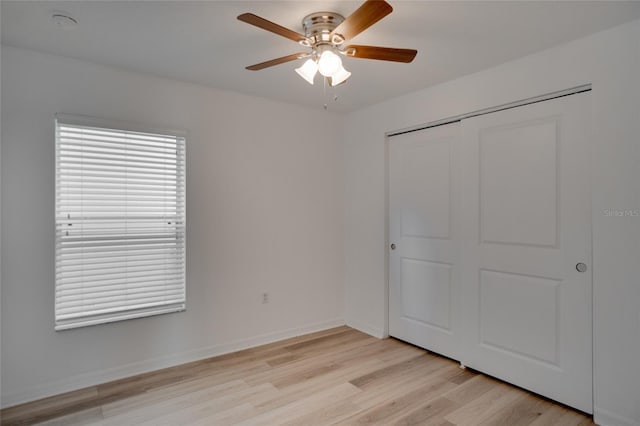 unfurnished bedroom with light hardwood / wood-style floors, ceiling fan, and a closet