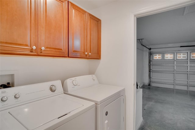 clothes washing area featuring cabinets and washer and clothes dryer