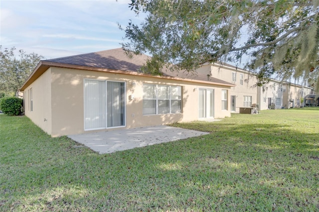 back of property with a lawn and a patio