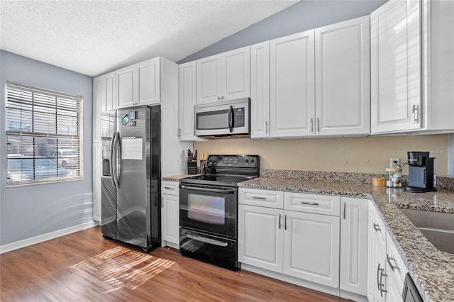 kitchen featuring white cabinets, light wood-type flooring, and appliances with stainless steel finishes