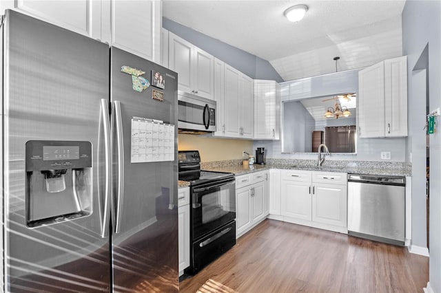 kitchen with white cabinets, sink, dark hardwood / wood-style flooring, light stone counters, and stainless steel appliances