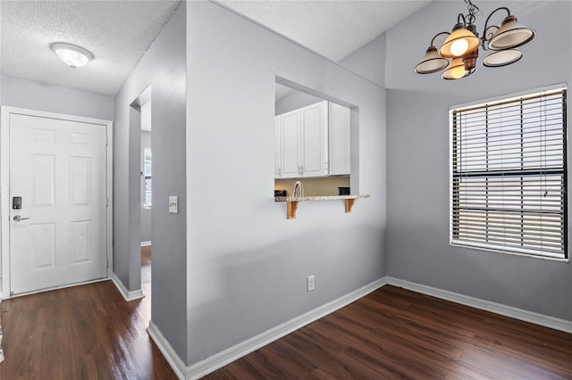 interior space with dark hardwood / wood-style flooring, a healthy amount of sunlight, and a notable chandelier