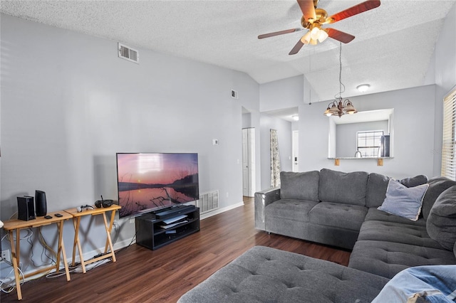 living room featuring a textured ceiling, dark hardwood / wood-style flooring, ceiling fan with notable chandelier, and lofted ceiling