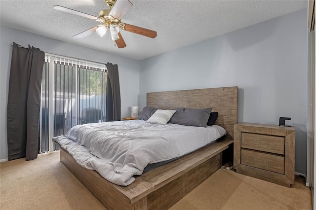 carpeted bedroom with ceiling fan and a textured ceiling