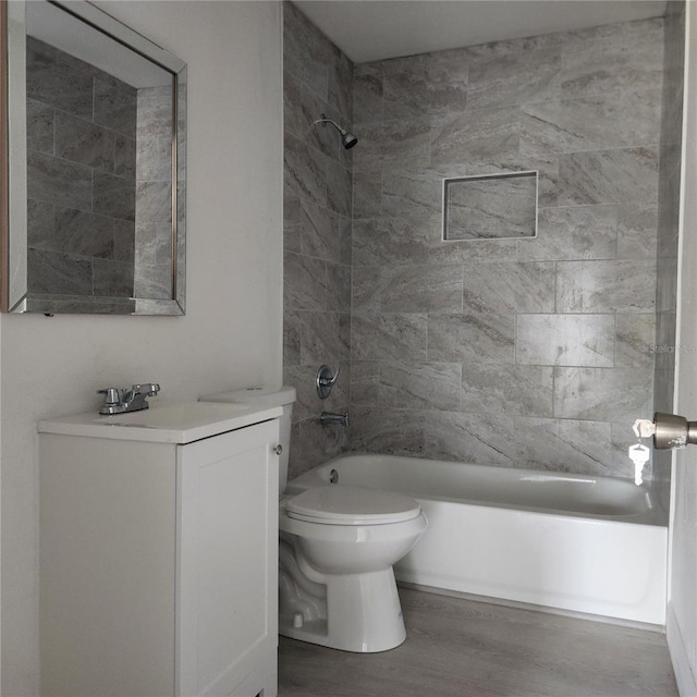 full bathroom featuring hardwood / wood-style flooring, toilet, vanity, and tiled shower / bath