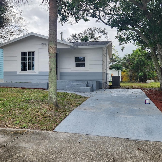 view of side of home with a lawn and central AC