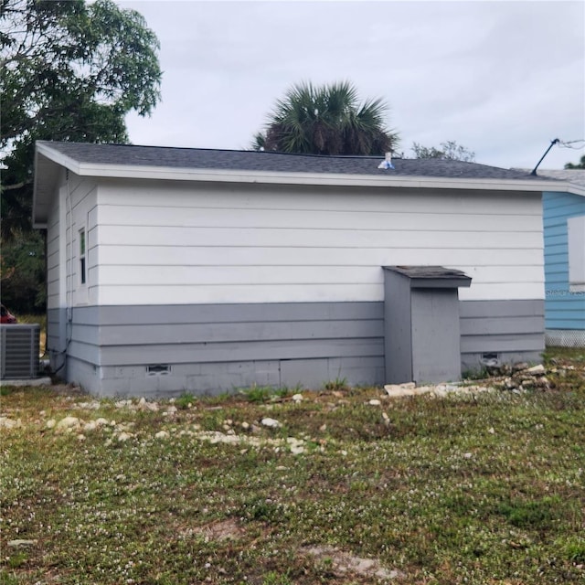 view of side of property featuring central air condition unit and a lawn