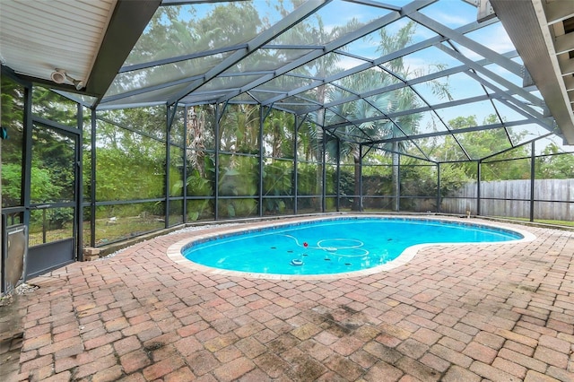 view of swimming pool featuring glass enclosure and a patio area