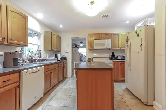 kitchen featuring sink, white appliances, a kitchen island, and light tile patterned flooring