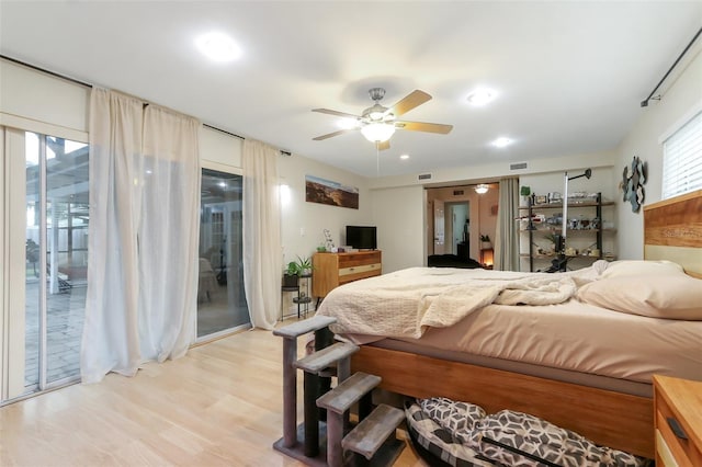 bedroom featuring ceiling fan, light hardwood / wood-style floors, access to exterior, and multiple windows