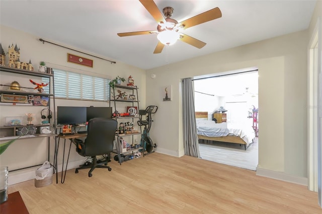 home office with light wood-type flooring and ceiling fan