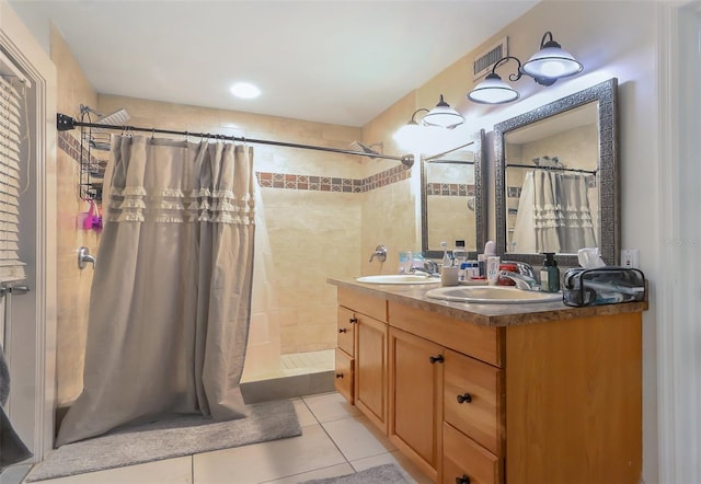 bathroom with tile patterned flooring, vanity, and walk in shower