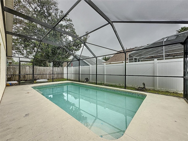 view of swimming pool with glass enclosure and a patio