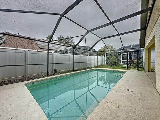 view of swimming pool featuring a patio and glass enclosure